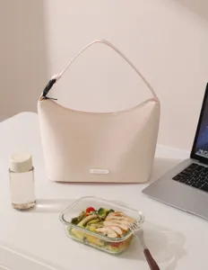 Close-up detail view of a chic beige oxford cloth bento lunch bag placed on a clean desk.