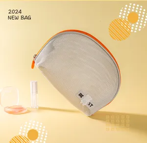 Close-up of portable semi-circular mesh cosmetic bag with orange zipper and bear tag.