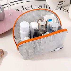 Portable semi-circular mesh cosmetic bag with orange zipper, ideal for travel and toiletries.