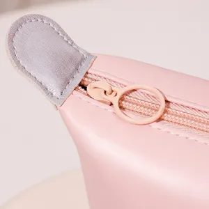 Pink PU leather dumpling cosmetic bag, stylish travel makeup pouch with zipper closure.