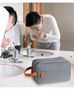 Detail view of the gray oxford toiletry bag with brown leather handle, ideal for travel.