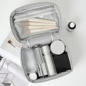 Portable grey makeup bag large capacity travel cosmetic organizer with multiple compartments inside.