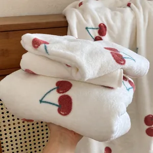 White fleece bath towel with cute red cherry pattern soft and cozy fabric detail view