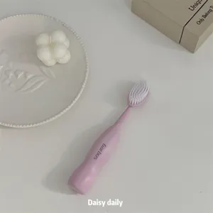 Vue détaillée de brosse à dents souple rose à large tête, outil de soin buccal quotidien.