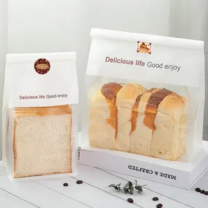 Detailed view of Thanksgiving bread packaging bags with festive sealing stickers on wooden table.