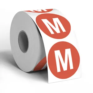 Nahaufnahme einer Rolle roter M-Größe Aufkleber für Kleidung und Verpackungsdetails im Detail.