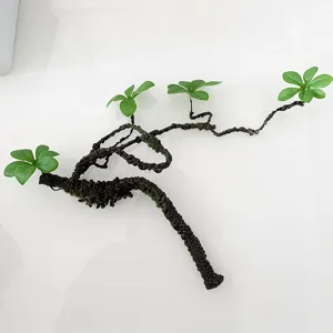 Gros plan d'une branche d'arbre en mousse artificielle avec des feuilles pour la décoration.