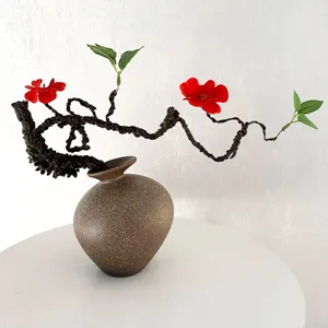 Detailed view showing artificial plum blossom branch with ceramic vase for elegant interior decor.