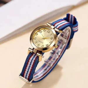 Primer plano reloj mujer cuarzo, caja dorada con correa lona rayas azul blanco rojo.