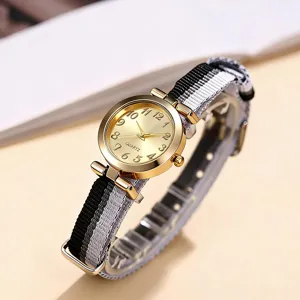 Reloj de cuarzo estilo universitario para mujer con caja dorada y correa de lona blanca negra.