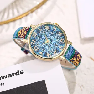 Close up view of bohemian style women quartz watch with colorful woven fabric strap and mandala dial.