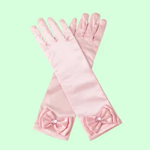 Detailed close-up of pink satin princess costume gloves featuring cute bows and rhinestones.