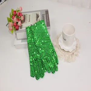 Detailed view of bright green sequin gloves placed on a white table with decorative props.