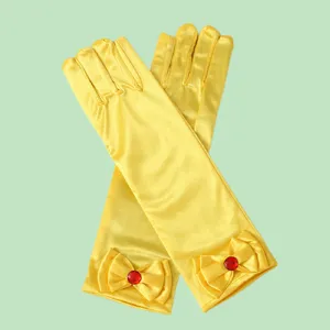 Detailed view of yellow satin princess gloves with bows and red gem for children performance.