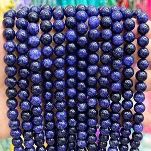 Vue détaillée de perles rondes en pierre précieuse violette pour des bijoux DIY.