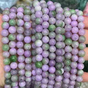 Vue détaillée de brins de perles rondes en pierres précieuses violettes et vertes, accessoires.