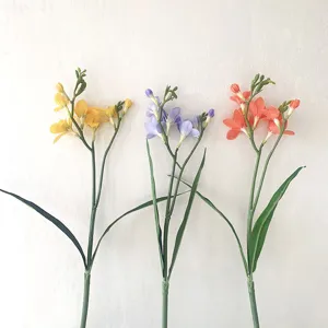 Dettaglio di fiori di freesia artificiali, steli floreali colorati per decorare casa nozze.