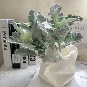 Detailed view of artificial dusty miller faux plant bouquet in white paper bag vase home decor.