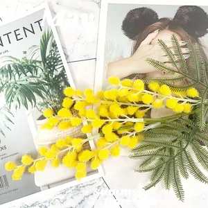 Gros plan de branche de mimosa jaune artificielle, fleurs pompons floquées pour déco.