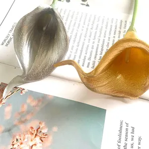 Gedetailleerde close-up van kunstmatige mini-calla's in zilver en goud, ideaal voor decoratie.