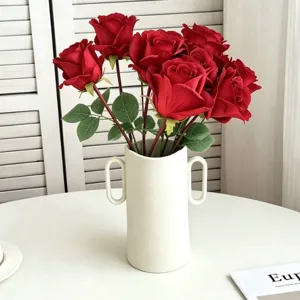 Künstlicher roter Rosenstrauß in weißer Keramikvase, ideal für Tischdeko und Wohnraumgestaltung.