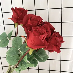 Detailansicht von künstlichen roten Rosen aus Seide mit realistischen Blättern für die Heimdeko.