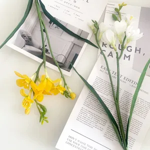 Dettaglio in primo piano di fiori di fresia artificiali gialli e bianchi per decorazioni.