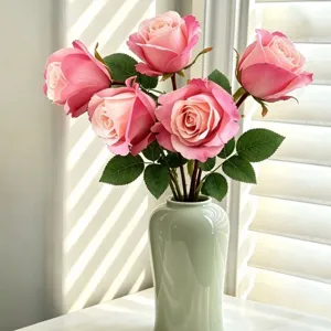 Künstlicher rosa Rosenstrauch in Keramikvase für Heimdekoration und Hochzeitsfeier.