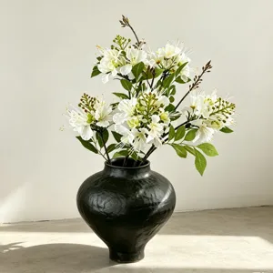 Künstlicher weißer Blumenstrauß in schwarzer Keramikvase, elegante Heimdeko Hochzeit.