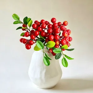 Artificial red berries flower arrangement with white ceramic vase for home desk decor.