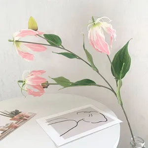Artificial gloriosa lily flower branch detail, pink and white petals with green leaves for home decor.