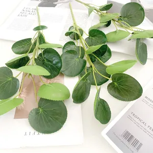 Detailed view of artificial green round leaves stems, realistic texture for floral arrangements.