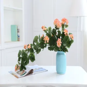 Artificial flower vine for home wedding restaurant decoration, fake plant in blue vase.