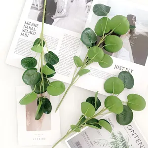 Detail view of artificial eucalyptus green leaf branches for floral arrangement and decor.