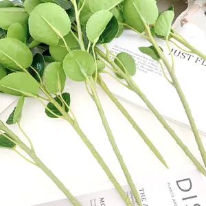 Close-up detail of artificial green golden pocket leaves, realistic touch glued foliage branches.
