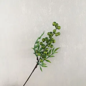 Dettaglio ramo di bacche verdi artificiali, frutto in schiuma realistico per arredo.