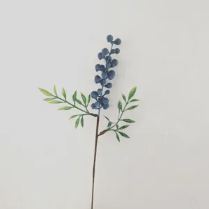 Primo piano dettagliato di stelo di finte bacche blu per bellissima decorazione floreale.