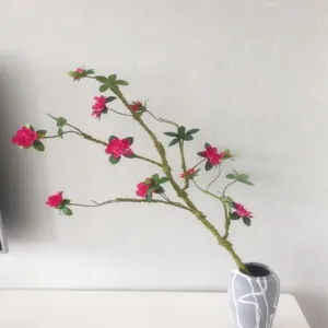 Primo piano di ramo di fiori di azalea artificiale con vaso per la decorazione domestica.