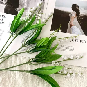 Close-up detail shot of artificial lily of the valley, soft plastic flower branch decor.