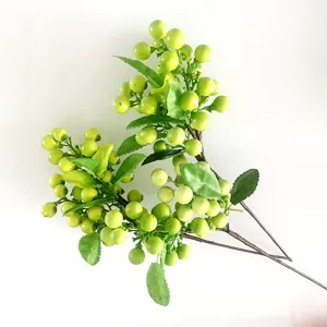 Detail shot of artificial green berries branch, realistic home decor floral plant arrangement.