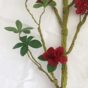 Primo piano del ramo di fiori di azalea artificiale con stelo in schiuma morbida e foglie verdi.