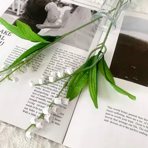 Artificial lily of the valley flower bouquet detail, faux rubber floral home decor.