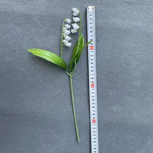 Detail view of artificial lily of the valley flower branch, soft rubber plastic plant for decor.
