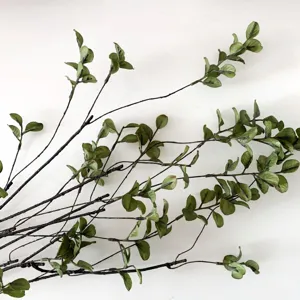 Kunstmatige groene bladdecoratietak in detail, ideaal voor hotel en restaurant styling.