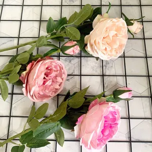 Vista dettagliata di ramo di fiori finti di rosa peonia rosa con foglie verdi per decorazione.