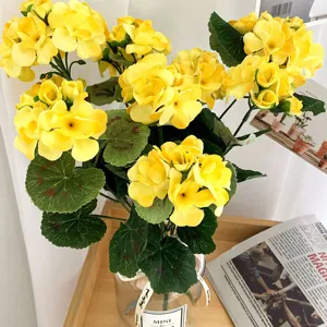 Artificial yellow silk flower arrangement in glass vase for home decor wedding table.