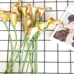 Close-up van gouden PU-calla's met groene stelen, perfect voor elegante huisdecoratie.