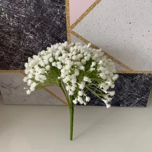 Vue rapprochée d'un bouquet de fleurs artificielles de gypsophile aux pétales blancs et verts.