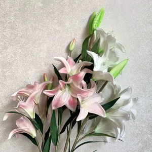 Close-up detail of artificial lily flower bouquet, showing realistic petals and green leaves.