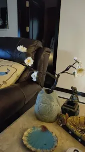 Chinese style artificial plum blossom branch with ceramic vase home living room decor detail.